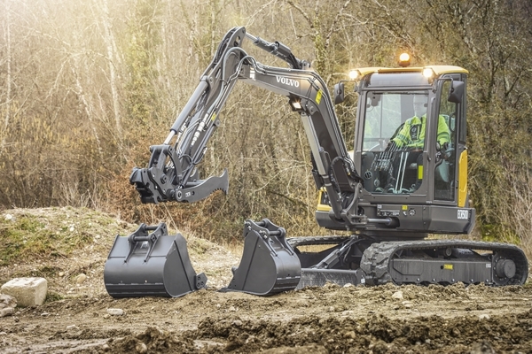 Pyöräkaivinkone asentamassa suoja-laitoja kaivantoon